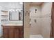 Bathroom featuring a vanity with drawers, large mirror, and a tiled shower at 10563 Pierson Cir, Broomfield, CO 80021