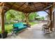 Relaxing covered patio featuring a ceiling fan, comfortable seating and a view of the lush, landscaped backyard with hammock at 10563 Pierson Cir, Broomfield, CO 80021