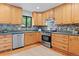 Well-lit kitchen with stainless steel appliances, wooden cabinets, and decorative tile backsplash at 10563 Pierson Cir, Broomfield, CO 80021