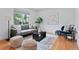 Cozy living room featuring a comfortable gray sofa, area rug, and a large bright window at 10563 Pierson Cir, Broomfield, CO 80021