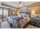 Relaxing bedroom featuring a decorative wood accent wall, fan, and door leading to a balcony at 12093 W Cross Dr # 304, Littleton, CO 80127