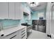 Bright laundry room with white cabinets and a utility sink at 6610 S Waco Way, Aurora, CO 80016