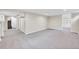 Large basement room with light gray carpet and open layout, leading to stairs and another room with shelves at 770 Locust, Denver, CO 80220