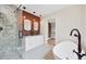 Modern bathroom featuring a glass shower, double sink vanity with exposed brick and a standalone soaking tub at 770 Locust, Denver, CO 80220