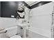 Stylish bathroom with white subway tile, a sleek pedestal sink, gold accents, and a black accent wall at 770 Locust, Denver, CO 80220
