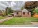 Charming brick house with a well-manicured lawn and a cozy outdoor seating area with a hot tub at 770 Locust, Denver, CO 80220