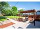 Landscaped backyard with stone lined lawn, stone patio and pergola with seating at 1955 Ingalls St, Lakewood, CO 80214