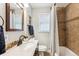 Cozy bathroom featuring neutral color palate with tiled shower and a vanity with stone countertop at 1955 Ingalls St, Lakewood, CO 80214