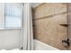 Beautiful tiled shower and tub combination with stylish shower curtain and shelving unit at 1955 Ingalls St, Lakewood, CO 80214
