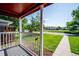 Charming front porch view with white railings looking out to a lush green lawn and quiet street at 1955 Ingalls St, Lakewood, CO 80214