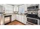 Well-lit kitchen with stainless steel appliances, tile backsplash, granite countertops, and modern fixtures at 1955 Ingalls St, Lakewood, CO 80214
