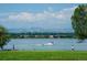 Scenic view of Sloan's Lake, with boats on the water, people walking along the shore, and mountains in the background at 1955 Ingalls St, Lakewood, CO 80214
