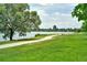 A calming walkway in Sloan's Lake Park, with mature trees, lush lawns, and the lake in the distance at 1955 Ingalls St, Lakewood, CO 80214