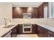 Well-equipped kitchen features dark wood cabinets and stainless steel appliances at 3150 Vallejo St, Denver, CO 80211