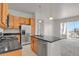Bright kitchen with granite countertops, stainless steel appliances, a kitchen island and balcony access at 14321 E Tennessee Ave # 1-301, Aurora, CO 80012