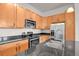 Close up of a kitchen with granite countertops, stainless steel appliances, and wood cabinets at 14321 E Tennessee Ave # 1-301, Aurora, CO 80012