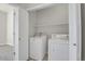 Laundry room with white washer and dryer units and storage shelf at 14321 E Tennessee Ave # 1-301, Aurora, CO 80012