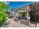 A covered back patio features stone accents, tiled flooring, and a black hot tub at 10761 Hillsboro Cir, Parker, CO 80134