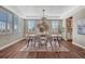 Dining room with tray ceilings, large windows, hardwood floors, and stylish chandelier at 10761 Hillsboro Cir, Parker, CO 80134
