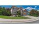 Landscaped home on a corner lot, showcasing the three-car garage, and manicured lawn at 10761 Hillsboro Cir, Parker, CO 80134