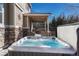 Back patio with hot tub, covered patio, and stone retaining wall for relaxing and outdoor enjoyment at 10761 Hillsboro Cir, Parker, CO 80134