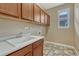 Functional laundry room features ample cabinet space and a utility sink by the window at 10761 Hillsboro Cir, Parker, CO 80134