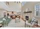 Spacious living room with fireplace, large windows, and hardwood floors, adjacent to kitchen at 10761 Hillsboro Cir, Parker, CO 80134