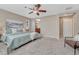 Neutral-toned main bedroom offers a ceiling fan and ensuite bathroom with a plush, neutral carpet at 10761 Hillsboro Cir, Parker, CO 80134