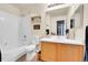 Bright bathroom featuring a shower-tub combo, wooden vanity, framed mirror and neutral walls at 5714 N Gibralter Way # 5-204, Aurora, CO 80019
