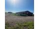 Exterior of a red barn with metal roof, located on a lot filled with weeds and gravel at 13291 N Harback Rd, Bennett, CO 80102