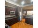 Spacious kitchen featuring stainless steel appliances, granite countertops, and hardwood floors at 13291 N Harback Rd, Bennett, CO 80102