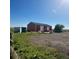 A Large outbuilding featuring multiple bays and a tractor to the side at 13291 N Harback Rd, Bennett, CO 80102
