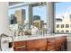 Elegant bathroom featuring a double vanity with marble countertops, wood cabinetry, and a bright window with city views at 1411 Wynkoop St # 806, Denver, CO 80202