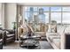 Bright living room featuring a comfortable sectional sofa and expansive city views through large windows at 1411 Wynkoop St # 806, Denver, CO 80202