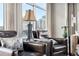 Living room close up with stylish chairs, lamp, and cityscape views through large windows at 1411 Wynkoop St # 806, Denver, CO 80202