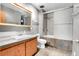 Bathroom with updated vanity, mirror, tiled floor, and shower-over-tub combo at 7610 S Garland St, Littleton, CO 80128