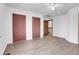 Bedroom featuring light wood-look floors, 2 large closets, and light colored walls at 7610 S Garland St, Littleton, CO 80128