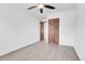 Bedroom featuring wood-look floors, closet with louvered doors, and a bright window at 7610 S Garland St, Littleton, CO 80128