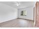 Bedroom features wood-look flooring, large window, and closet with louvered doors at 7610 S Garland St, Littleton, CO 80128