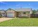 Inviting single-story home featuring an attached garage, well-kept lawn and traditional design at 7610 S Garland St, Littleton, CO 80128