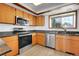 Well-lit kitchen featuring stainless appliances, wood cabinets, granite countertops and a modern design at 7610 S Garland St, Littleton, CO 80128