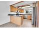 Modern kitchen featuring stainless appliances, wood cabinets, granite countertops and ample natural light at 7610 S Garland St, Littleton, CO 80128