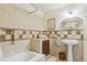 Tiled bathroom with a bathtub, pedestal sink, and elegant fixtures, perfect for a relaxing experience at 7289 Stroh Rd, Parker, CO 80134
