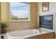 Soaking tub featuring mosaic tile and natural light at 7289 Stroh Rd, Parker, CO 80134
