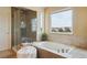 Bathroom with a soaking tub, walk-in shower, and a large window at 7289 Stroh Rd, Parker, CO 80134