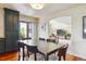 Open dining room with hardwood floors, modern table, and access to the living room and backyard at 7289 Stroh Rd, Parker, CO 80134