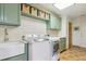 Well-organized laundry room features cabinets, counter space, a sink and modern appliances at 7289 Stroh Rd, Parker, CO 80134