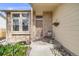 Inviting entryway with decorative brick accents, colorful garden, and a cozy seating area at 9032 W Arizona Dr, Lakewood, CO 80232