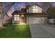 Charming two-story home with brick accents, manicured lawn, and an attached two-car garage at 9032 W Arizona Dr, Lakewood, CO 80232