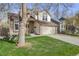 Charming two-story home with brick accents, attached garage, and well-manicured front lawn at 9032 W Arizona Dr, Lakewood, CO 80232